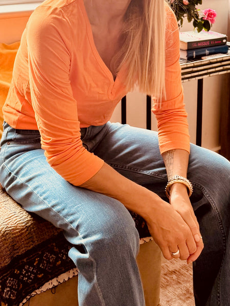 Woman wearing deep purple long sleeve V-neck top - perfect fit styling
